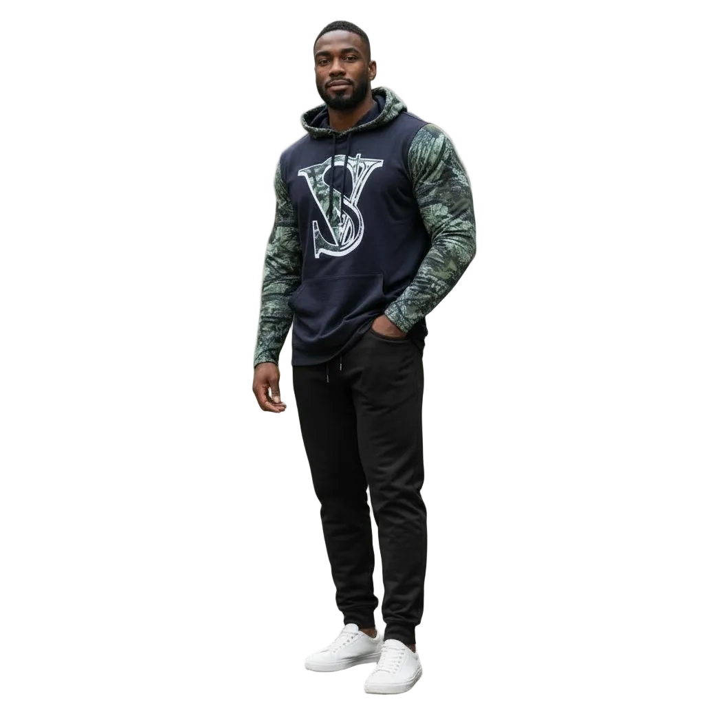 Man wearing a black hoodie with a logo and camouflage sleeves in an urban setting.
