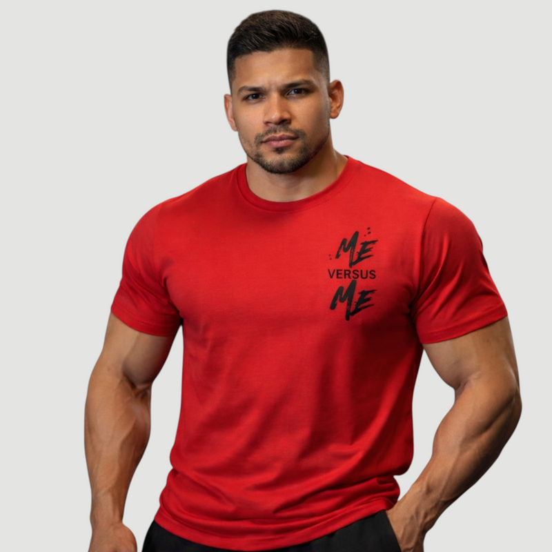 Man wearing a red t-shirt with 'Me Versus Me' text on a gray background